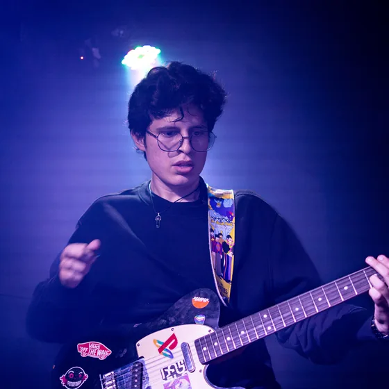 Guitarrista de Fotofobia bajo luz azul