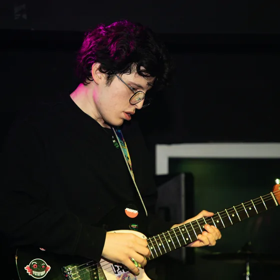 Guitarrista de Fotofobia bajo luz verde